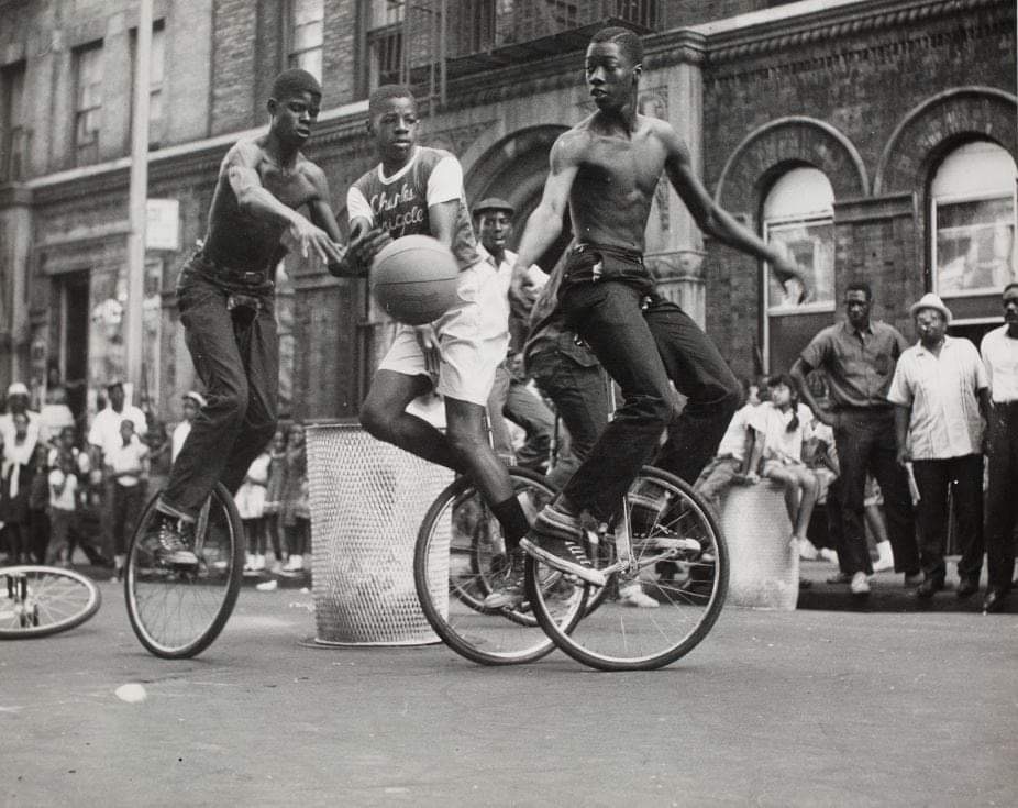 three people on unicycles play basketball