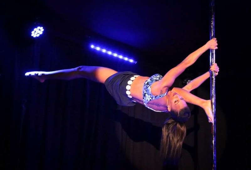 Candace Cane performs an overspilt on the pole