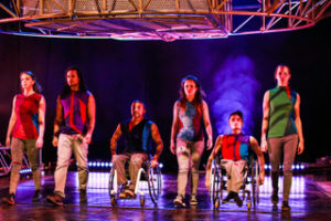 able-bodied and disabled circus performers walk in a line