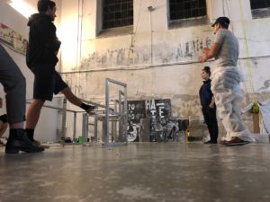 A group of people work together to make a set in a large building