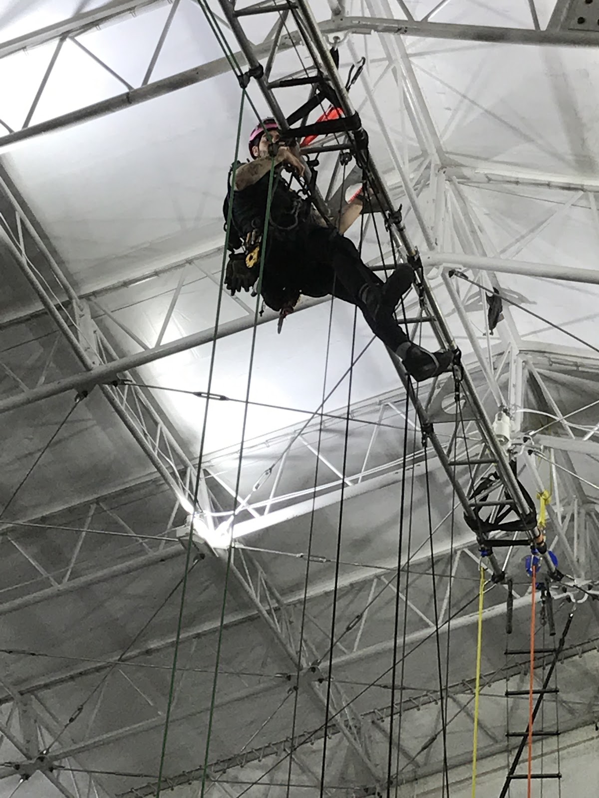 A rigger performs a rigging inspection in the ceiling