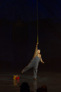 Michael Jay Garner circus clown in Kooza reaches high balanced on one foot