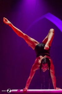 Nadine Louis holds a handstand on stage