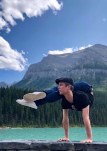 Alexey Goloborodko performs a back-bending handstand in front of a mountain and a lake