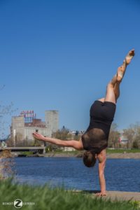 Marie-Ève Dicaire does a one-armed handstand next to a body of water