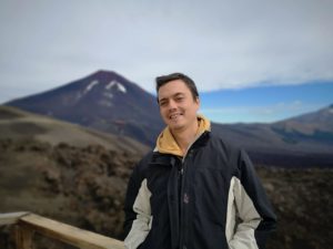 Javier Morales sonríe en frente de una montaña