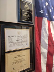 A photo of Them Wall's award next to an American flag