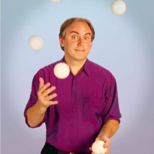Alan Howard juggling in a purple polo
