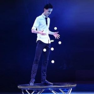 Alan Sulc juggles balls against a platform on stage
