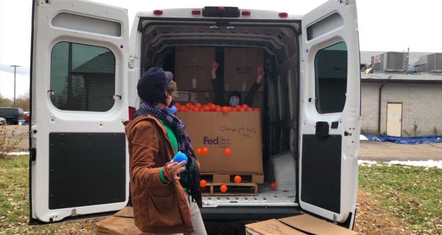 Benjamin Domask-Ruh stands in front of a white cargo van, ready to transport ball pit balls