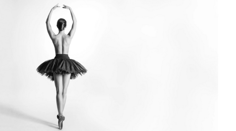 Artistic athlete: a ballerina, en pointe, with her back to the camera.