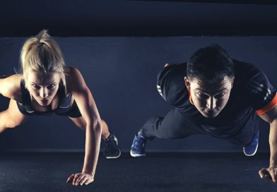 male and female athletes or circus performers train by doing pushups