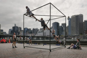 Australian circus artists climb a cube-shaped apparatus
