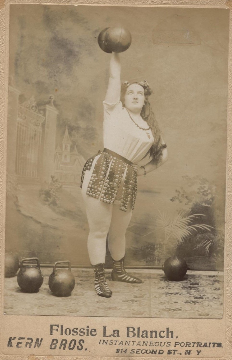Flossie La Blanche, circus strongwoman, on sepia postcard