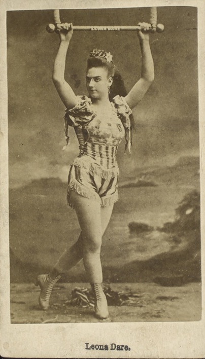Women in Circus History: Leona Dare, American acrobat, on trapeze. Sepia photograph