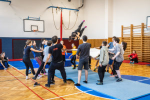 CIRQUEON training activity- circus artists in a gym practice over mats and a trampoline