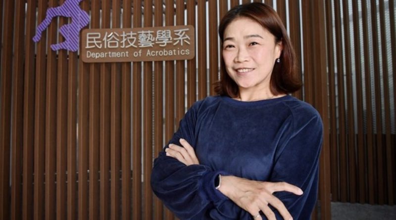 Ching-Lan Chang, professor at Taiwan's National College of Performing Arts and Department of Acrobatics chair, posed in front of the Department sign