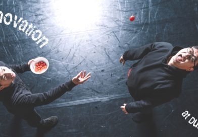 Male Taiwanese juggling duo does a trick where one throws cherry tomatoes into the other's mouth