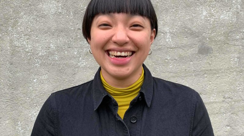 Yu-Lun Chiang, Taiwanese acrobat and co-founder of [], smiles for the camera. She has short hair and a yellow shirt