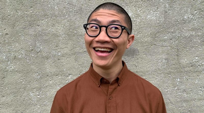 Taiwanese acrobat Hsing-Ho Chen, former Cirque du Soleil performer, with close-cropped hair, thick glasses, and an orange button-up
