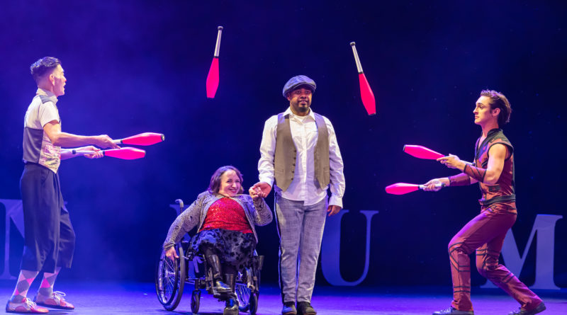 Diverse cast of Omnium Circus' "I'mPossible"- Between two pin jugglers (Rob Lok and Elan España), Ermiyas Muluken escorts Suzanne Richard across stage in her wheelchair