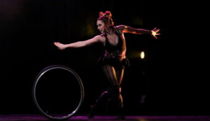 Cirque Mechanics acrobat, a female cyr wheel performer in a dark leotard