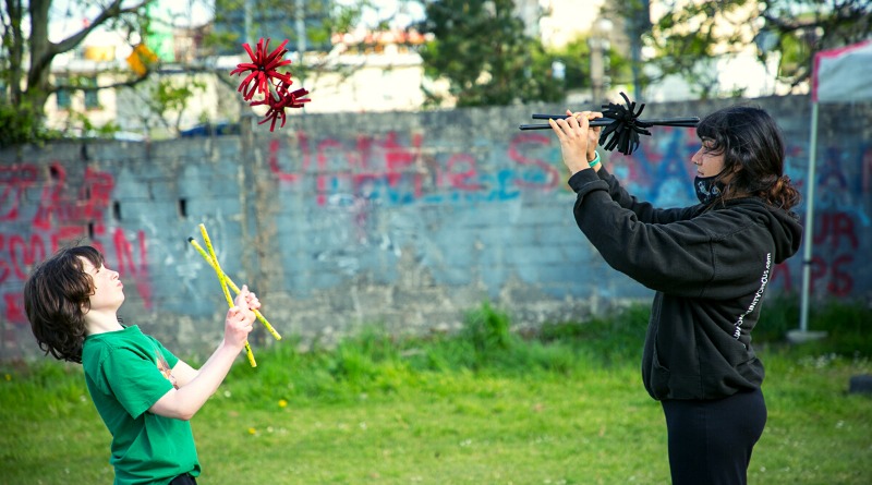 In Galway, Ireland, two social circus practitioners engage in game of devil sticks.