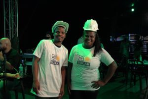 From Circo Crescer e Viver Solar Circus project, two Brazilians solar panel traineers in Circo Solar t-shirts and white hard hats pose for a photograph