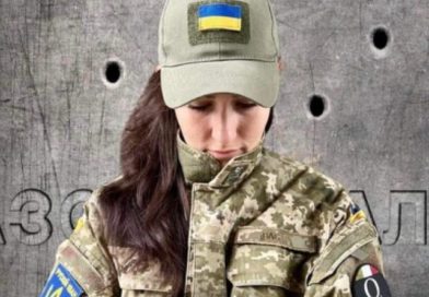 Nadya Vasina, Ukrainian circus performer, activist, and Radio Kyiv FM journalist, wears camo and a cap with the Ukrainian flag to show support for Ukraine