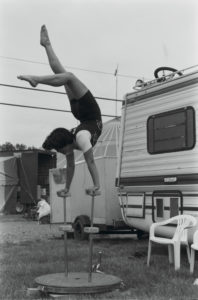 Kelly Miller Circus performer balances on hand-stilts in front of his circus trailer. Image taken by Dawn V. Rogala, featured in Smithsonian National Museum of American History