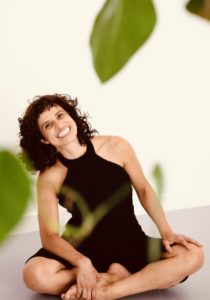 Rosiris Garrido, Berlin-based pilates instructor and aerialist, sits cross-legged in her studio