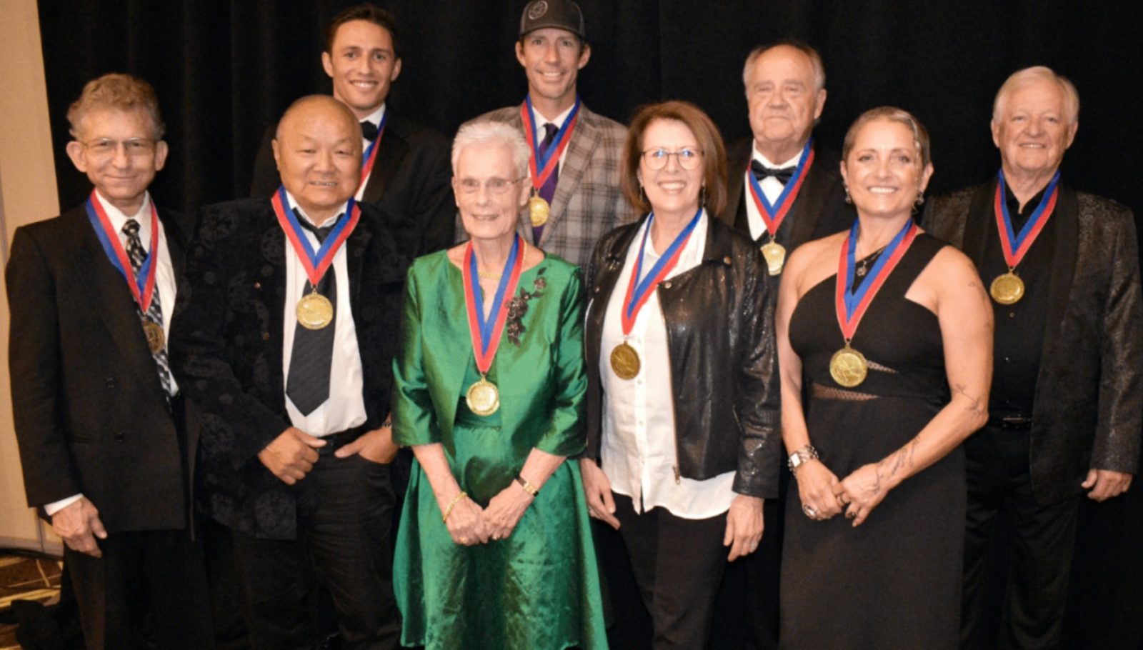 At the World Acrobatics Society's 2022 Hall of Fame Ceremony, the nine inducted athletes and performers wear their medals for a group photo