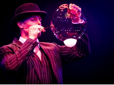 Performer Denis Lock in "Opium" show in Las Vegas. He does a bubble trick with both a wand and straw to make a large bubble