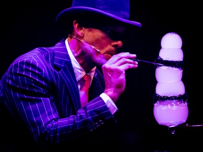 Spiegelworld performer Denis Lock blows a stack of bubbles through a straw