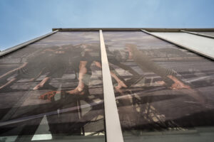 Two banners of Gaby Merz' photographs hang on the outside of the El Invernadero circus greenhouse in Madrid