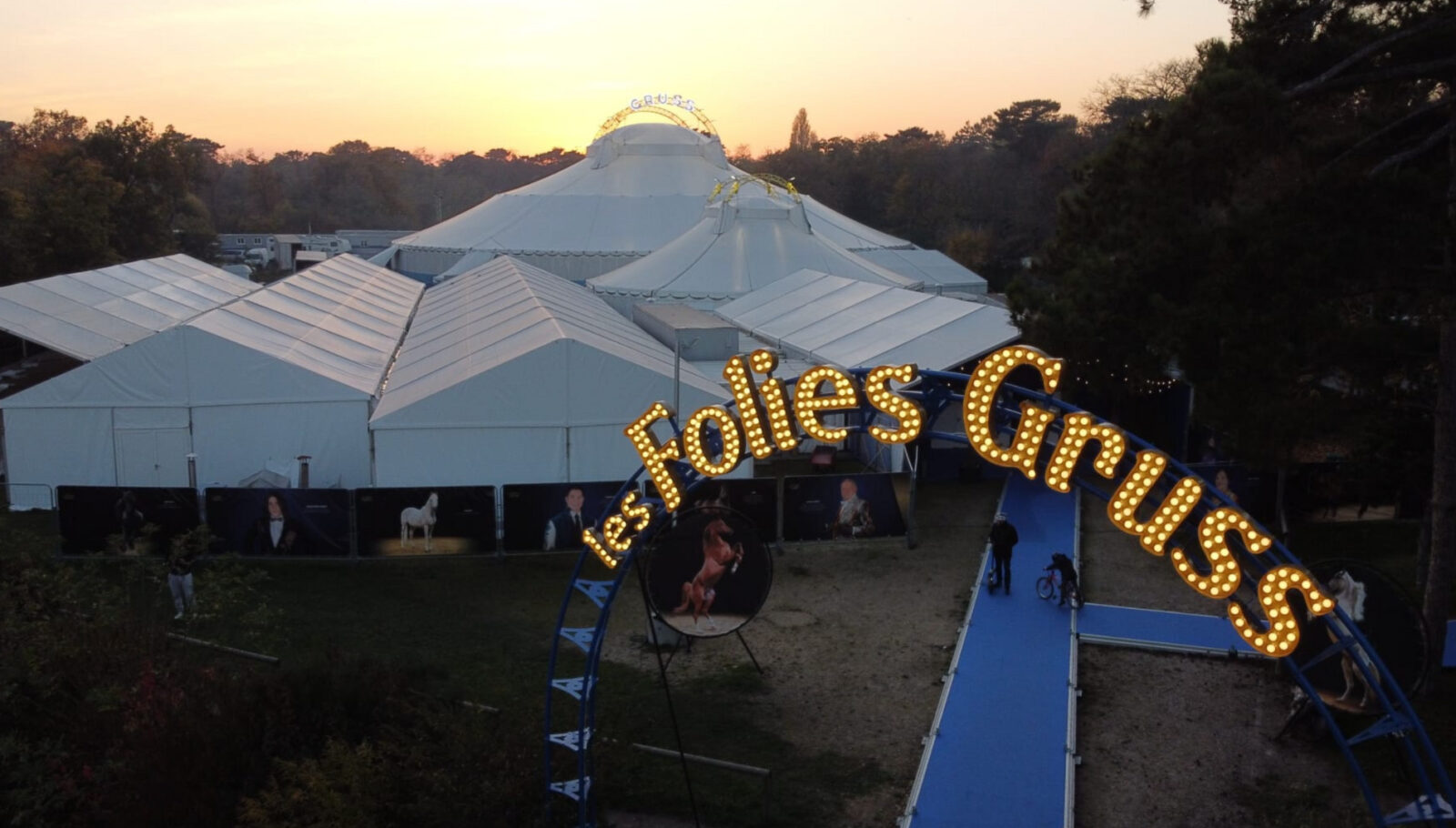 Les Folies Gruss circus sign shows the company name in lights in front of a large tent complex outside of Paris