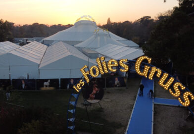 Les Folies Gruss circus sign shows the company name in lights in front of a large tent complex outside of Paris