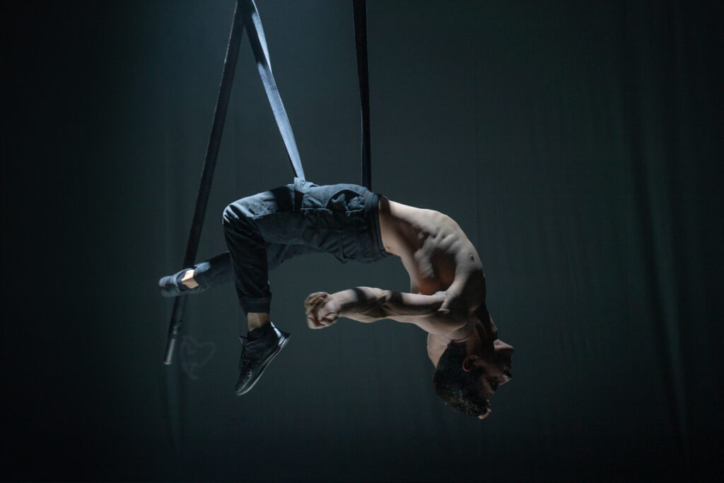 Mexican performer Emmanuel Garcia hangs horizonally from his aerial straps