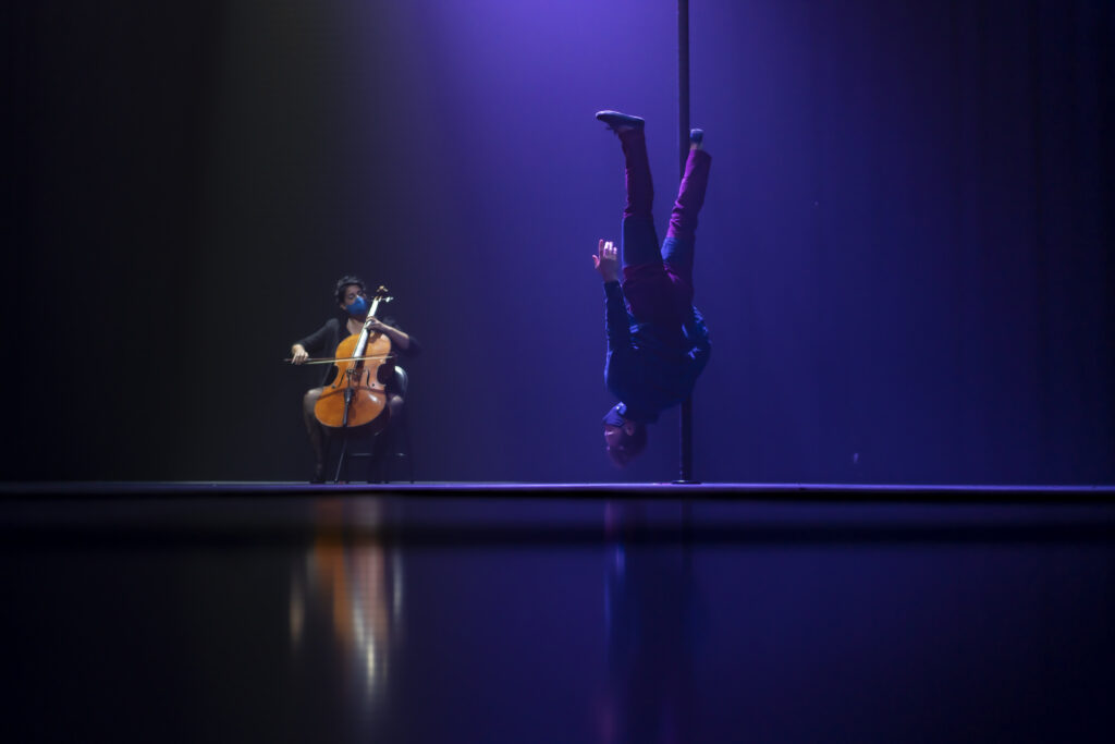 American circus performer Evgeny Kurkin does his Chinese pole act, accompanied on stage by a seated violinist