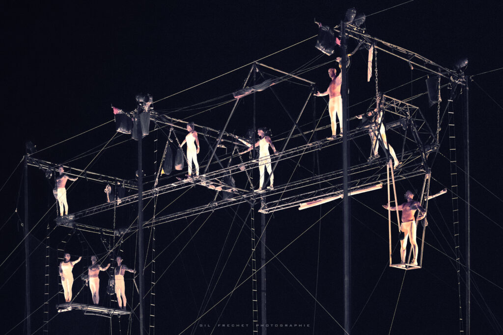 French flying trapeze company La Tangente du Bras Tendu performers in "Resistance," their show done on a large, trapezoidal metal apparatus