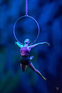 Aerialist Kalista Russell hangs from an aerial hoop by just her chin