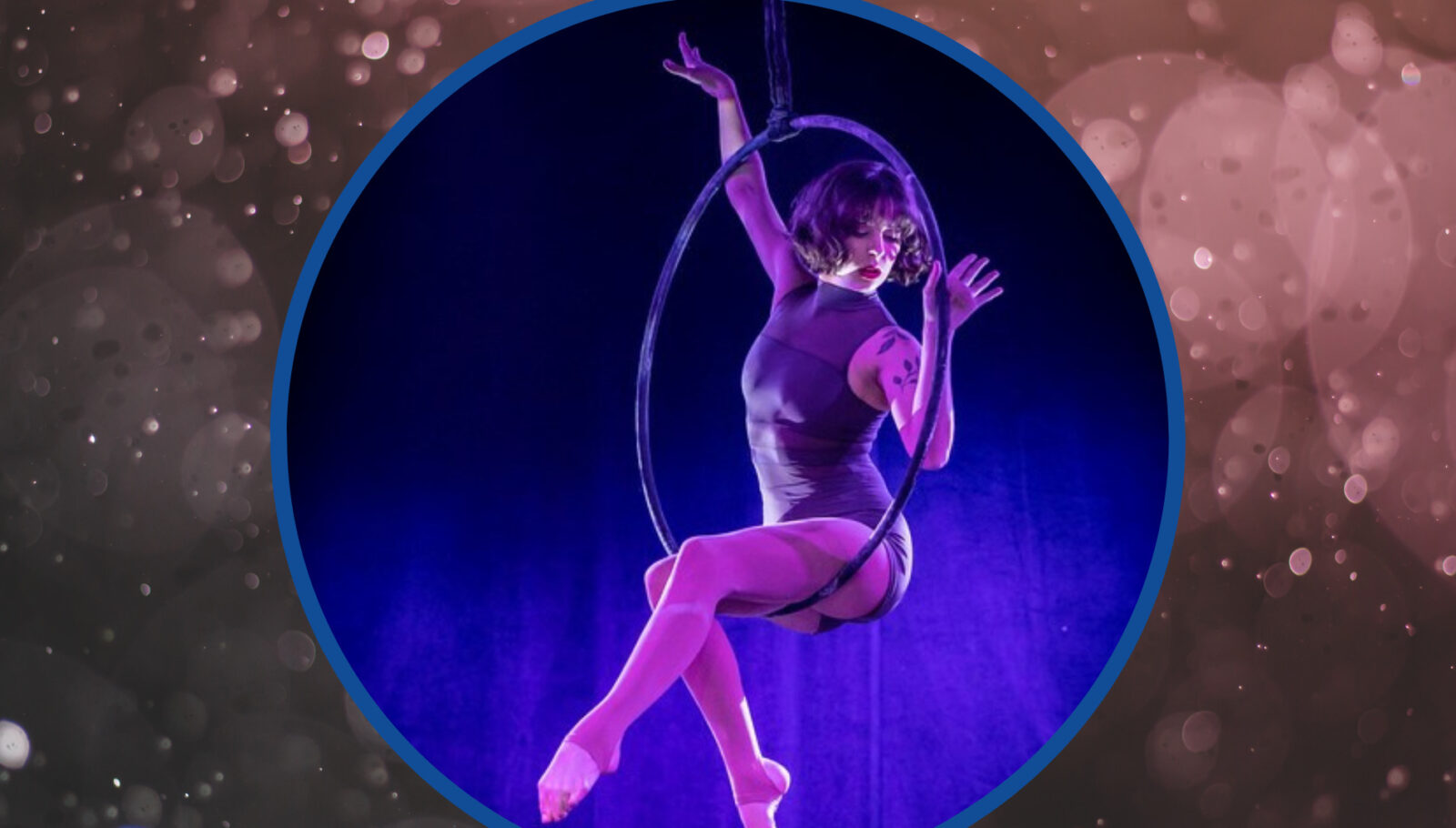 Aerialist Kalista Russelll, the 2023 VIVA Fest Emerging Aerial Hoop winner, perches gracefully on her lyra while performing her VIVA act