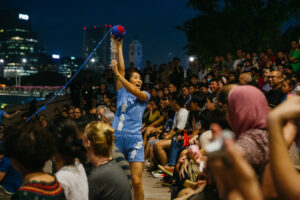Nighttime performance of Bonfire Circus' show "Forget-Me-Not" in Singapore, where a female circus artist smiles over her shoulder at the audience