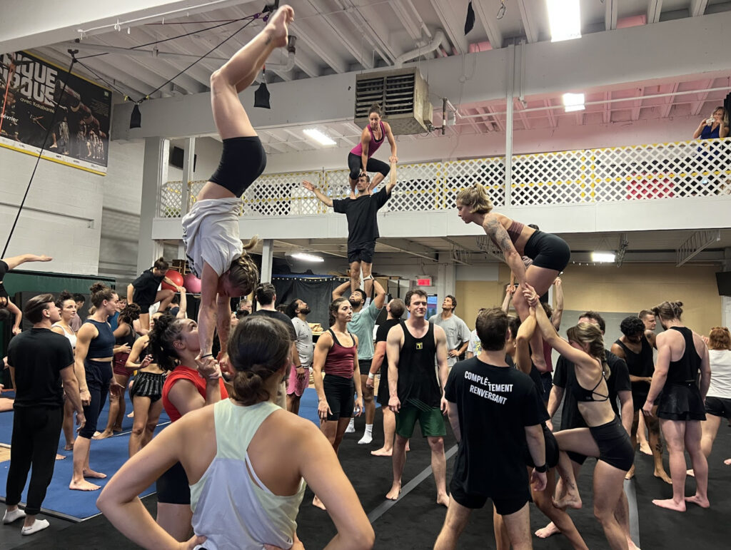 Young adult circus artists rehearse new acrobatic stunts together in the Kalabanté Productions training studio. This session was part of Gravity and Other Myths' Casting Jam at  Montreal Completement Cirque 2023