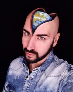 3D makeup effects artist Luca Luce shows off one of his own designs, an illusion that makes it look like his bald head is split in half to show a painted globe inside of it