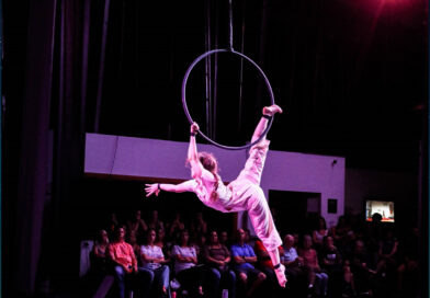 American female acrobat Veronika Agle reaching out to the crowd in her Lyra/aerial hoop routine at San Diego Circus Festival 2023